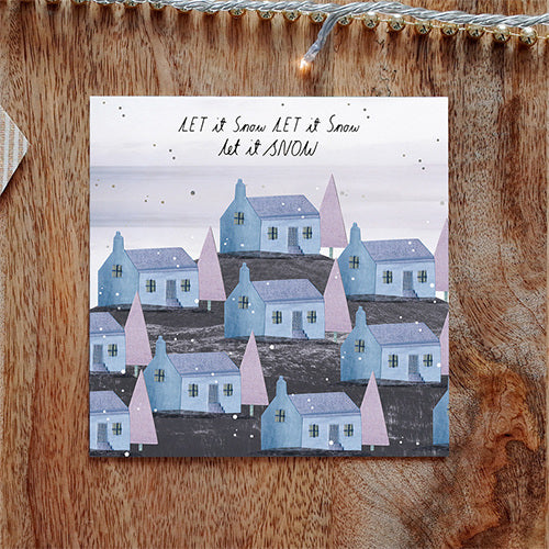 Christmas card. Painted styled illustration showing a rows of houses on a hill with a tree next to each house. Snow is falling over the scene. 