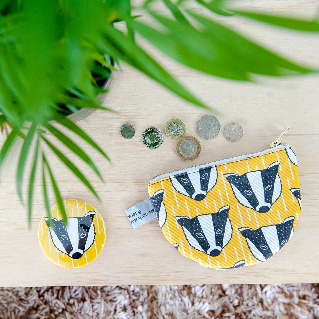 Lifestyle image of yellow and white geometric patterned fabric with black and white illustration of badger.