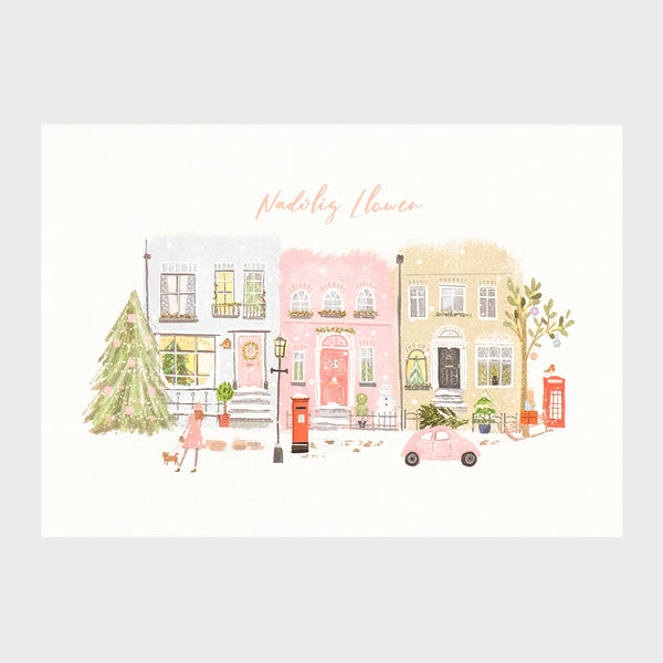 Watercolour and digital illustration on shimmering Pearlescent background. Row of houses with festive decorations and foliage. Christmas tree on the street, red phonebox and postbox, with a lady walking her dog. 