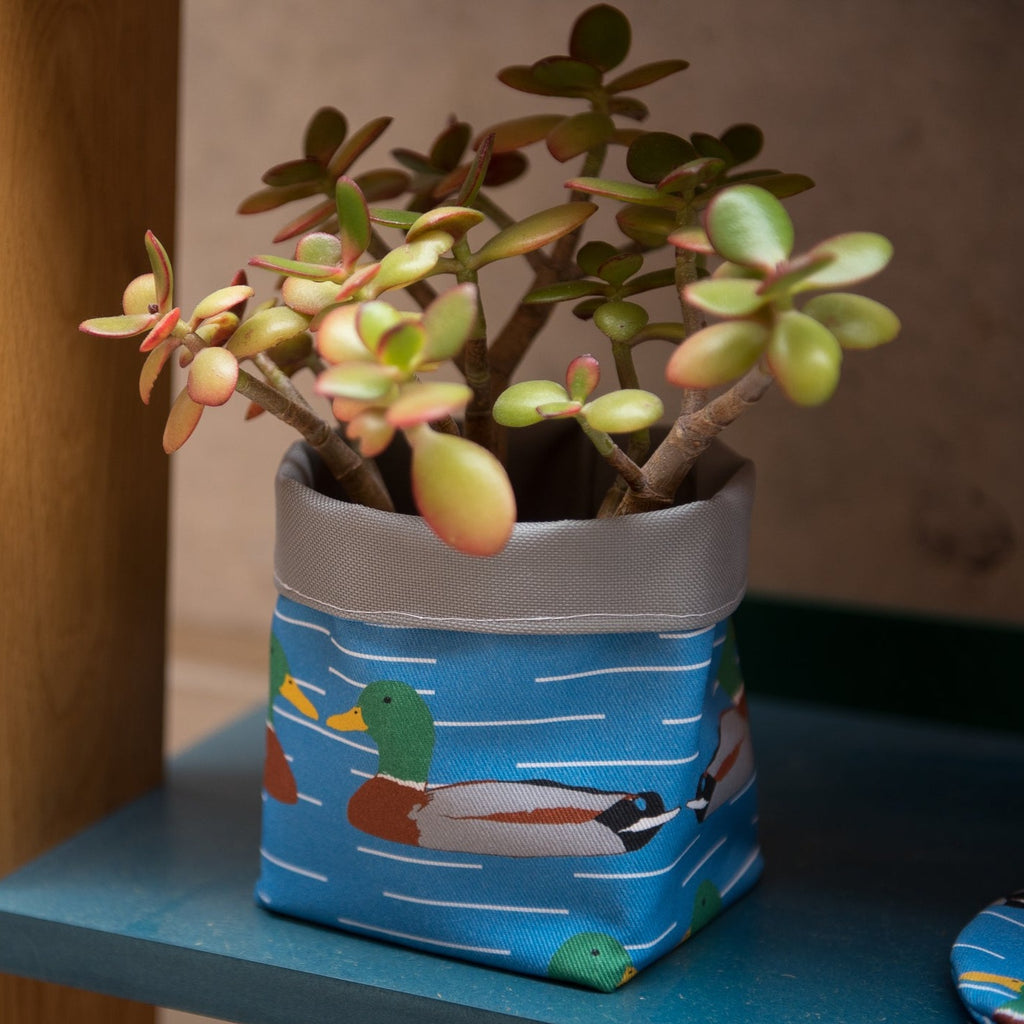 Blue graphic printed fabric plant pot holder with duck motif.
