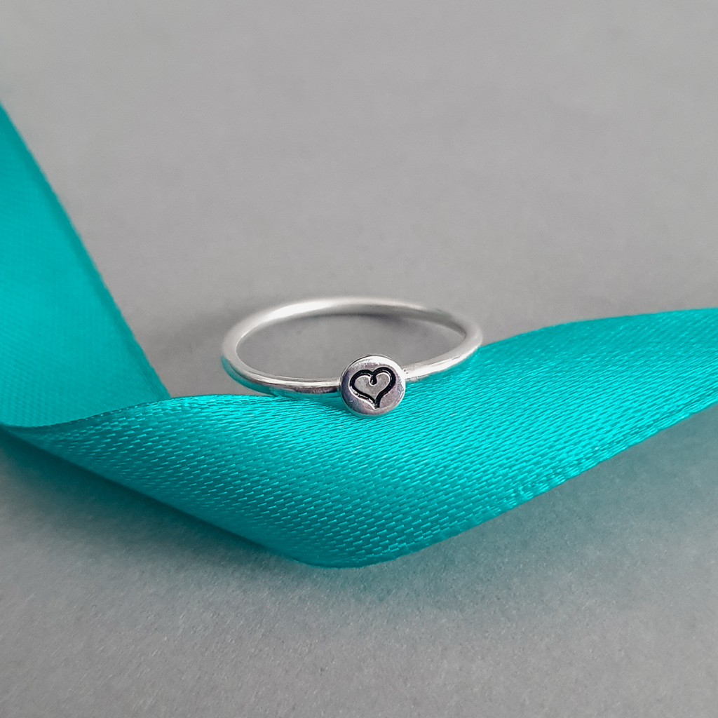 Product image with ribbon.  Sterling silver stacking ring with heart motif.