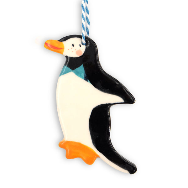 Ceramic hanging Christmas decoration. Penguin in side profile wearing a blue bowtie. Hangs from blue and white twine.  