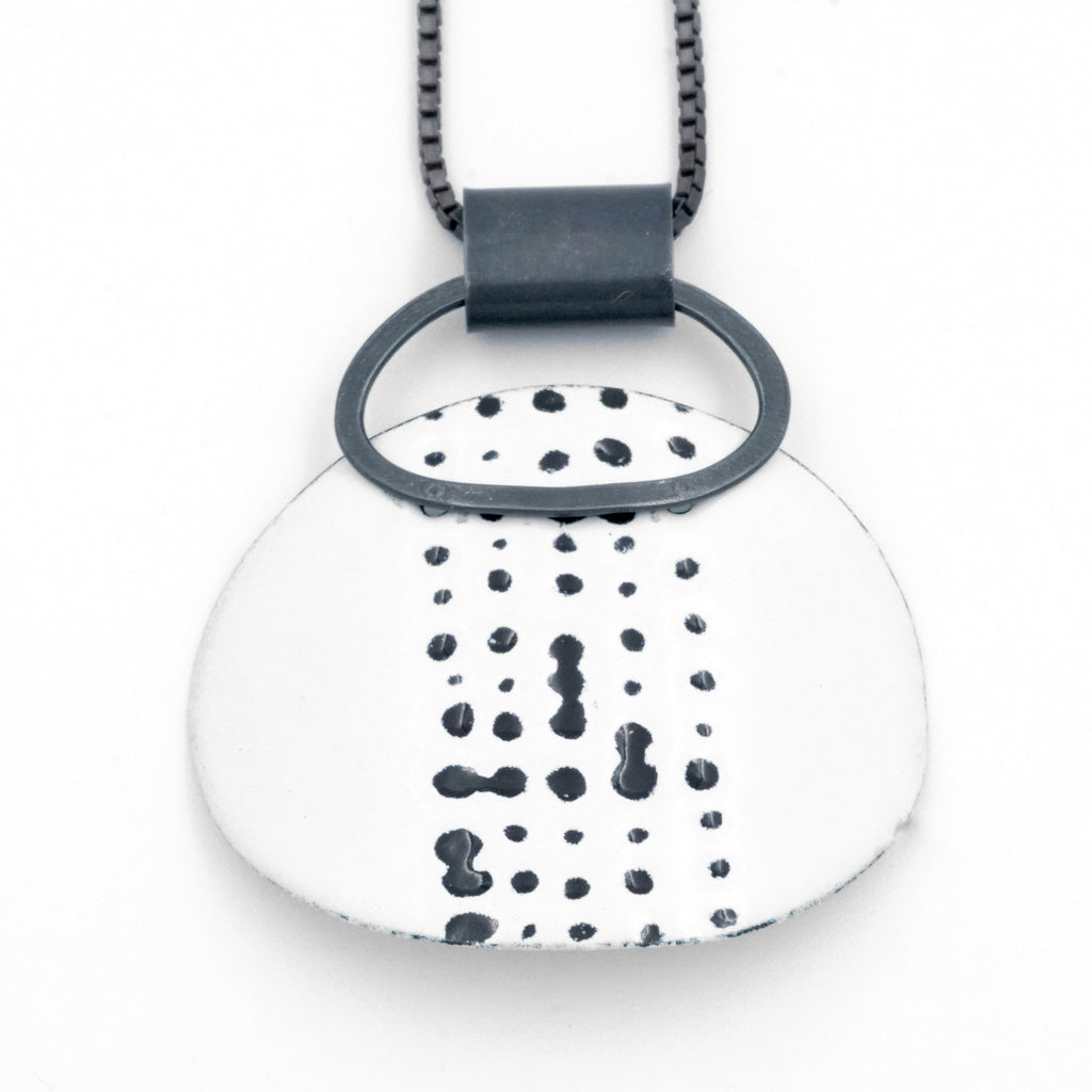 White enamel marked loop stud pendant. Large white curved oval feature with black markings etched on the surface. 