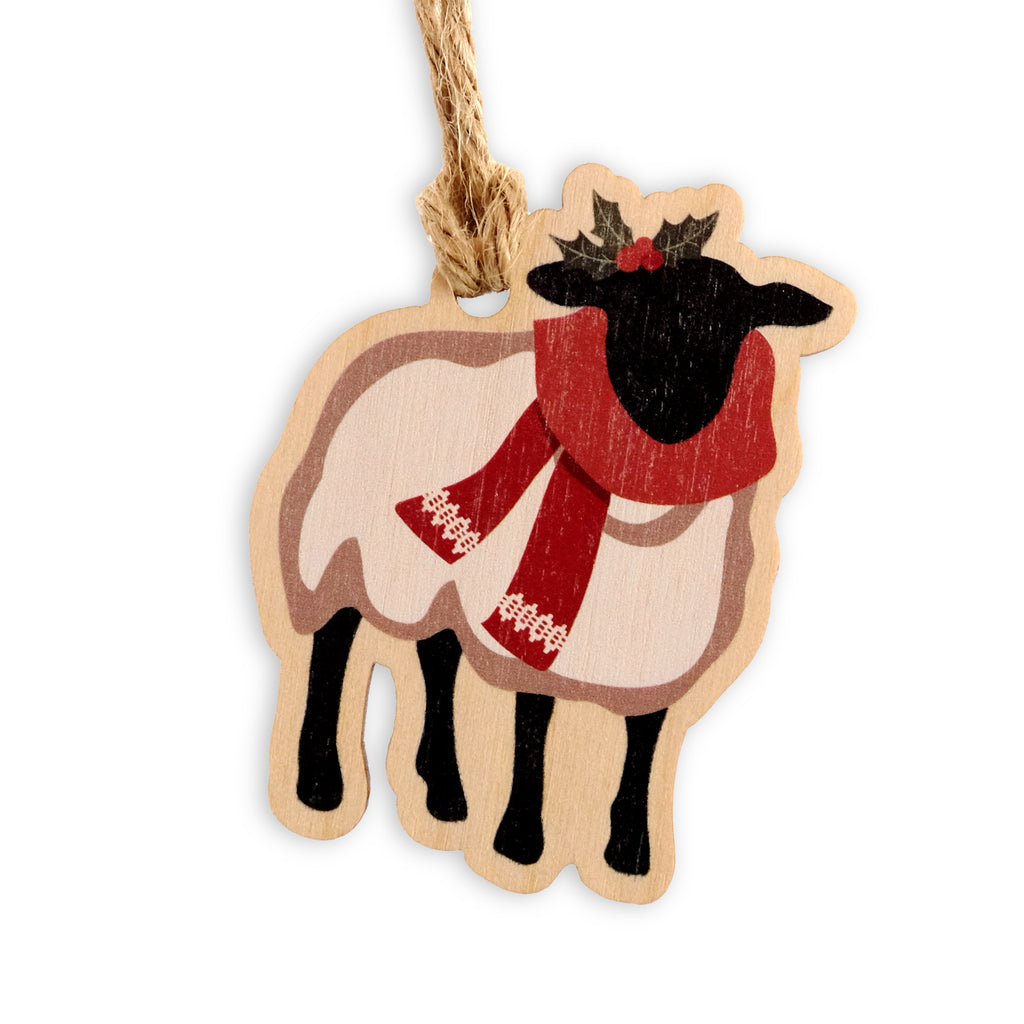 Laser cut wooden sheep shaped Christmas decoration. Sheep illustration wearing a red festive scarf with a sprig of holly on its head.