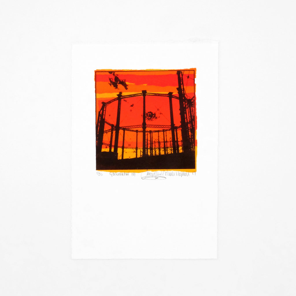 This is an image of a portrait oriented screenprint. The artwork is a square panel surrounded by a white border. It depicts the silhouette of a gasometere against an industrial background. The colours in the image are black, red, orange, yellow and deep peach. The artwork is signed and editioned. 