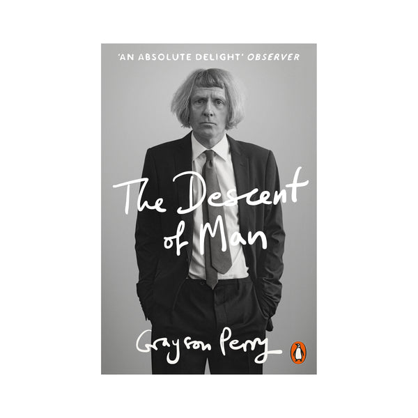 Cover for 'the descent of man' by Grayson Perry. Black and white photograph of the artist wearing a formal suit and tie, with his hands in his pockets. white text in a handwritten font overlaid.