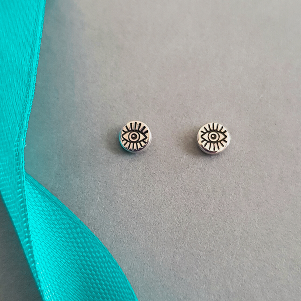 Product image.  Small sterling silver stud earrings with evil eye motif.