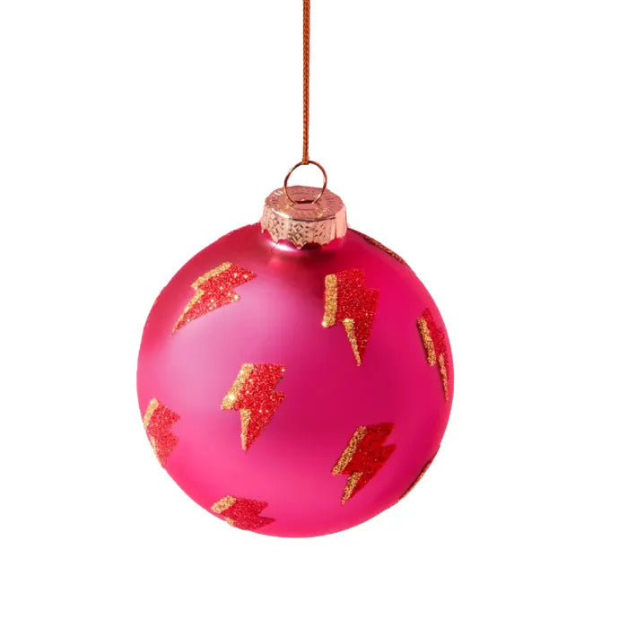 Bright pink glass bauble with red and gold glitter lightning bolts all over